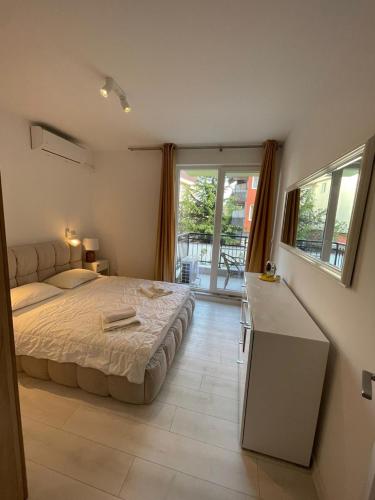 a bedroom with a bed and a desk and a window at Sun&Moon Apartment Obzor in Obzor