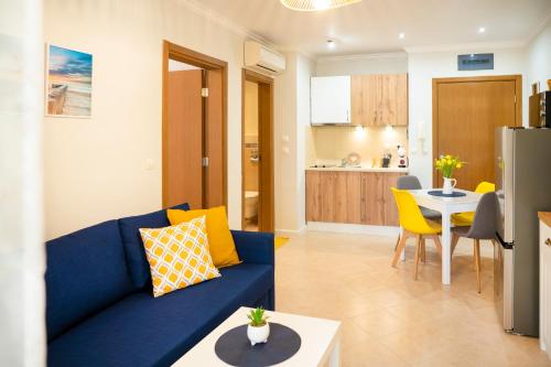 a living room with a blue couch and a kitchen at Cozy Home Santa Marina in Sozopol