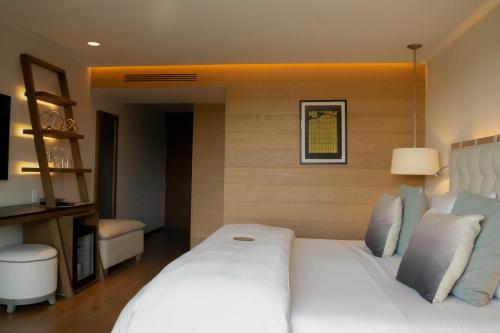a bedroom with a large white bed in a room at Cartesiano Boutique & Wellness Hotel in Puebla
