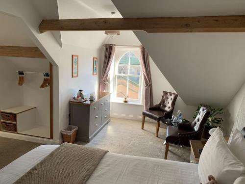 a bedroom with a bed and two chairs and a window at The Middleham in Whitby