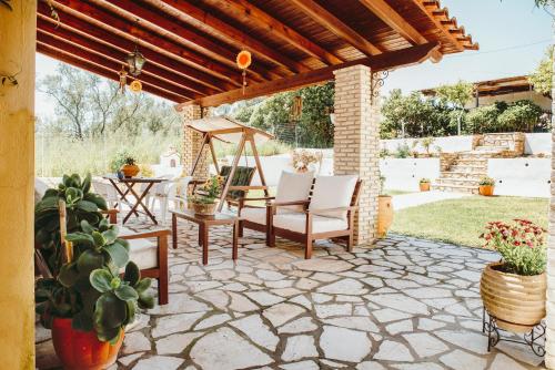 an outdoor patio with a wooden pergola at Serenità in Lefkimmi