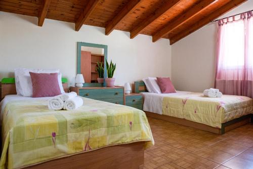 a bedroom with two beds with towels on them at Serenità in Lefkimmi