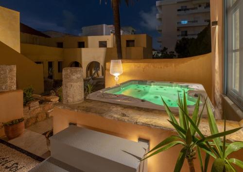 a jacuzzi tub on the balcony of a house at night at Casa del Sol Suites in Rhodes Town
