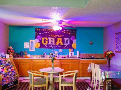 un comedor con una mesa y una señal de graduación púrpura en Grandview Plaza Inn, en Junction City