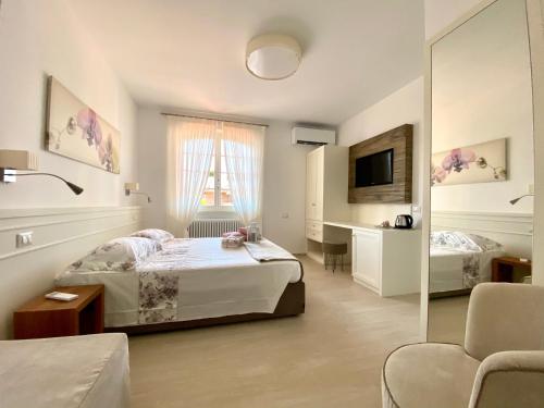 a bedroom with a bed and a desk and a tv at Bellaisa Bed & Breakfast in Camaiore