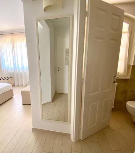 a bathroom with a mirror and a white door at Bellaisa Bed & Breakfast in Camaiore