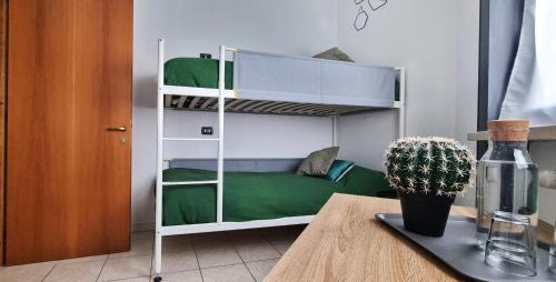 een kamer met een stapelbed en een tafel bij Guesthouse Tree Rooms Industrial in Bergamo