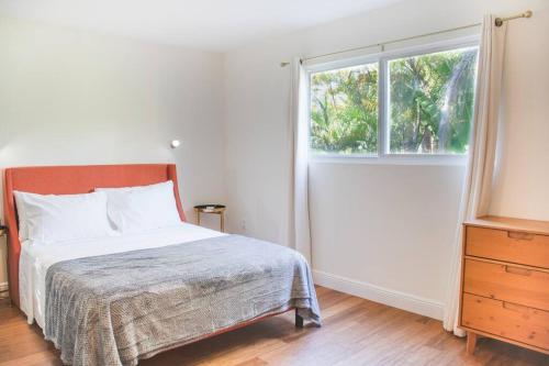 a white bedroom with a bed and a window at Coconut Grove Hidden Sanctuary Townhouse in Miami