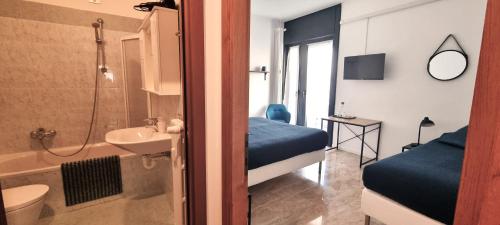 a bedroom with a bathroom with a bed and a sink at Guesthouse Tree Rooms Industrial in Bergamo