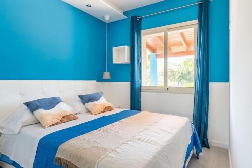 1 dormitorio con paredes azules y 1 cama con almohadas en Villa Luisa Il Giardino sul mare, en Sciacca