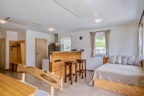 a bedroom with a bed and a table in a room at 4Luxuriöses Ferienhaus in traumhafter Landschaft in Döbriach