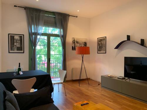 a living room with a table and a tv at Hermoso piso en el centro de Barcelona in Barcelona