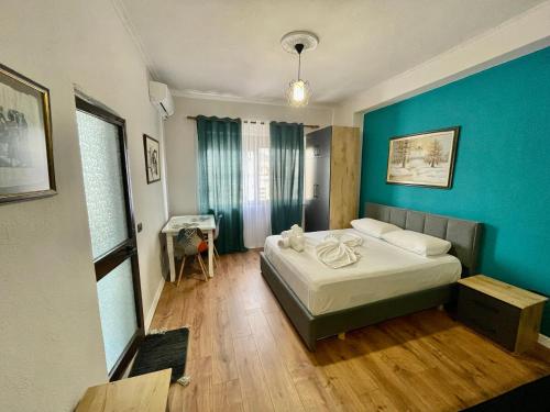 a bedroom with a bed and a blue wall at Keon superb studio apartament in Tirana