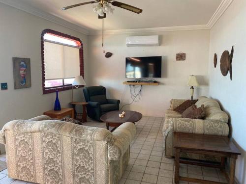 a living room with two couches and a tv at Beachfront, 2 bedroom Condo in San Felipe in San Felipe
