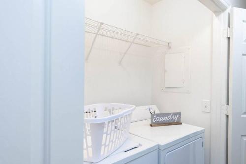 a white laundry room with a basket on the counter at Sleeps 8, Lake Lanier Hidden Gem in Buford