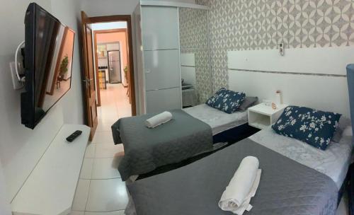 a small bedroom with two beds and a mirror at Apartamento Condado de Majorca in Capão da Canoa