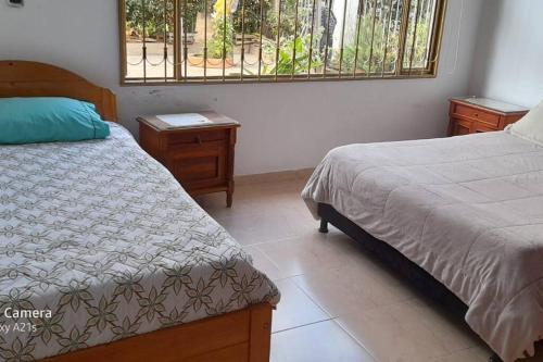 um quarto com 2 camas e uma janela em Preciosa casa de descanso a 10 min de Villa de Leyva em Sutamarchán