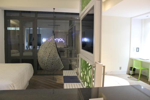 a room with a bed and a room with a mirror at WeEnjoy Hotels Grand Prix Aeropuerto CDMX in Mexico City