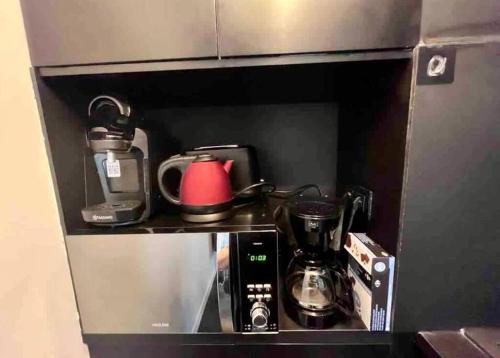 a small kitchen with a coffee maker and a microwave at Un été sans fin à Deauville in Deauville