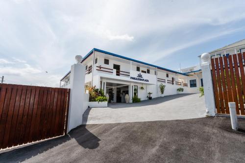 a white building with a gate and a fence at Parguera Plaza Hotel - Adults Only in La Parguera