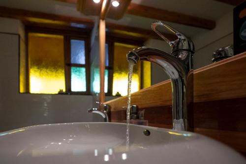 a bathroom sink with water coming from a faucet at Hotel Spa Casa de Adobe Villa de Leyva in Villa de Leyva