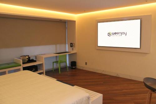 a room with a projection screen on the wall at WeEnjoy Hotels Grand Prix Aeropuerto CDMX in Mexico City