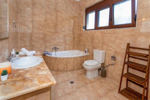 uma casa de banho com uma banheira, um WC e um lavatório. em Blue Panorama Villas em Giannoudi