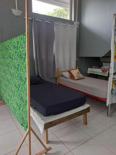 Zimmer mit 2 Etagenbetten und einem Fenster in der Unterkunft Laure hébergement loue lits en dortoir in Faaa
