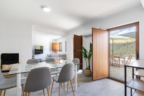 a dining room and living room with a table and chairs at Casa das Domingas in Vide
