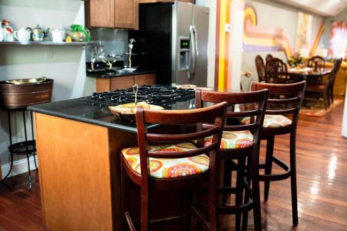 a kitchen with a stove and some bar stools at Retro-inspired Content House In Patterson Park in Baltimore