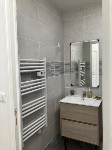 a bathroom with a sink and a mirror at Makivka - A 5 min de Cognac - Maison entière avec 2 chambres in Boutiers-Saint-Trojan