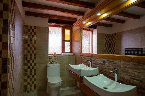 a bathroom with two sinks and a toilet at Hotel Spa Casa de Adobe Villa de Leyva in Villa de Leyva