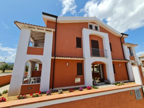une grande maison orange avec des garnitures blanches dans l'établissement Le Anfore di Nora Domo, à Pula