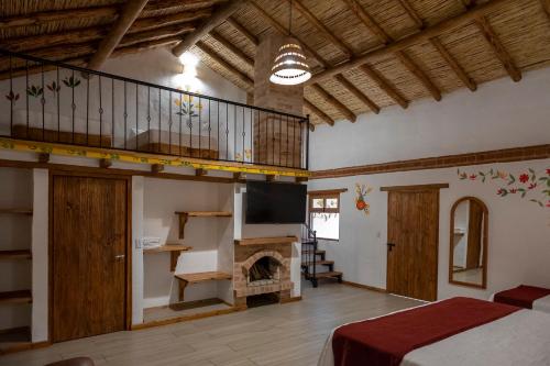 a bedroom with a fireplace and a bed in a room at Hotel Spa Casa de Adobe Villa de Leyva in Villa de Leyva