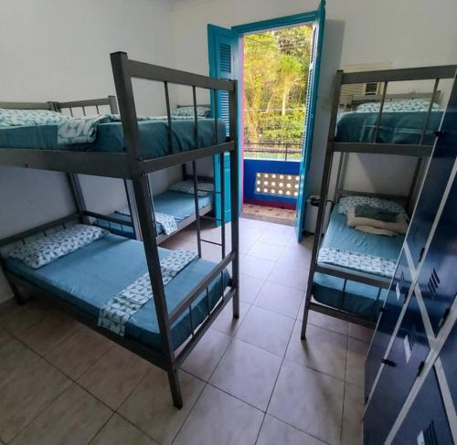 2 Etagenbetten in einem Zimmer mit Fenster in der Unterkunft Rolds Hostel in Santos