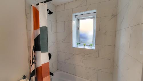 baño con ducha y ventana en JstLikeHome - Serenity Suites en Ottawa