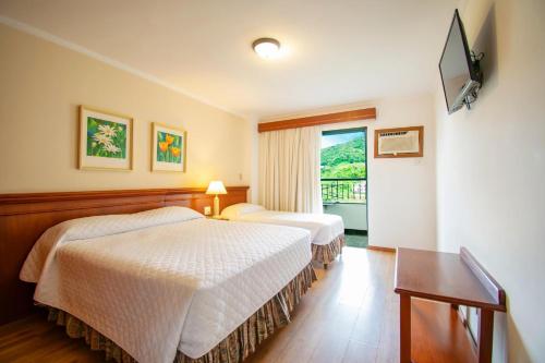 una camera d'albergo con due letti e una televisione di Hotel Monte Real ad Águas de Lindóia