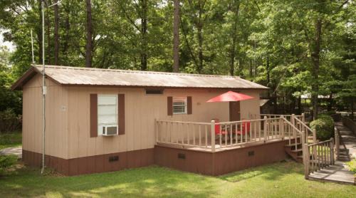 a small house with a porch and a deck at Sunburst RV Resort in Whitfield