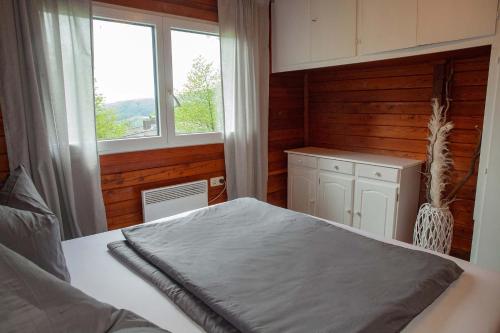 - une chambre avec un grand lit et une fenêtre dans l'établissement Ferienhaus Auszeit, à Lindenfels