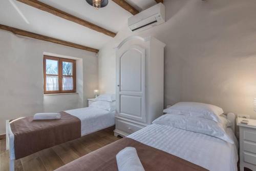 布耶的住宿－Heritage Villa Croc，一间卧室设有两张床和窗户。
