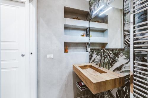 La salle de bains est pourvue d'un lavabo en bois et d'une plante. dans l'établissement MiCo CityLife LuxuryFlat, 100m METRO, à Milan