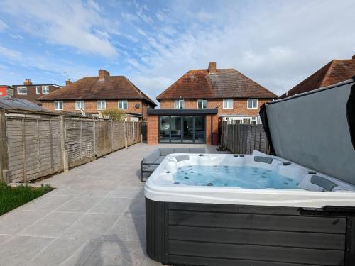 a hot tub on the patio of a house at Malthouse Cottage in West Wittering