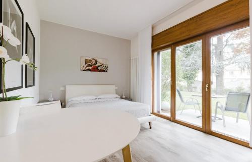biały pokój z łóżkiem i oknem w obiekcie Relax & Emozioni Rooms w mieście Valeggio sul Mincio