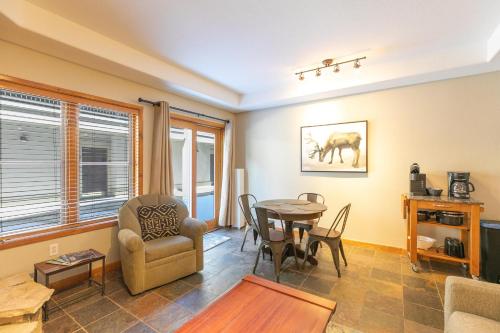 a living room with a table and a chair at Riverbend Centennial Run Condo: Ski In/Out in Breckenridge