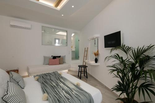 uma sala de estar branca com um sofá e uma televisão em Naxos Hotel Poseidon em Naxos Chora