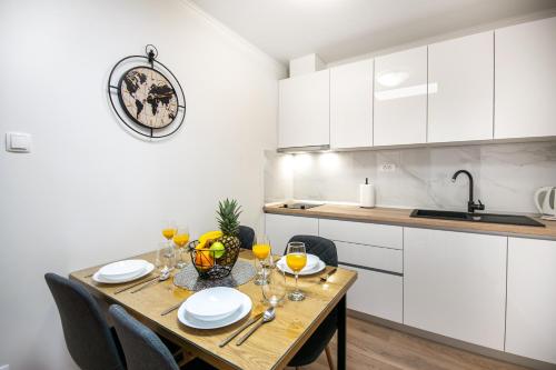 eine Küche mit einem Holztisch mit Weingläsern darauf in der Unterkunft Apartmani Rita in Baška Voda