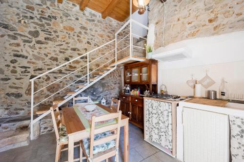 a kitchen with a staircase in a stone wall at Agriturismo Nonnamelia in Nasino