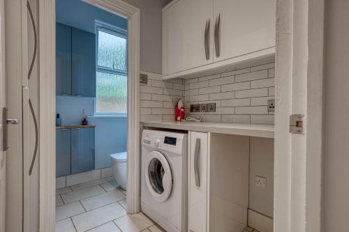 uma lavandaria com máquina de lavar e secar roupa em Stunning 6 bed in Nottingham - Sleeps 16 em Nottingham