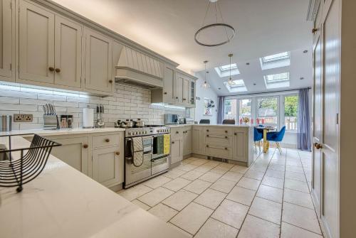 a large kitchen with white cabinets and a kitchen island at Spacious House in Nottingham - Sleeps 16 in Nottingham