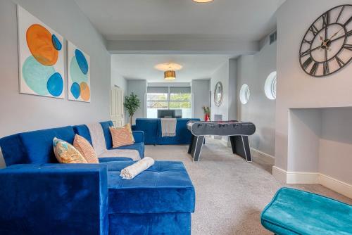a living room with a blue couch and a piano at Spacious House in Nottingham - Sleeps 16 in Nottingham